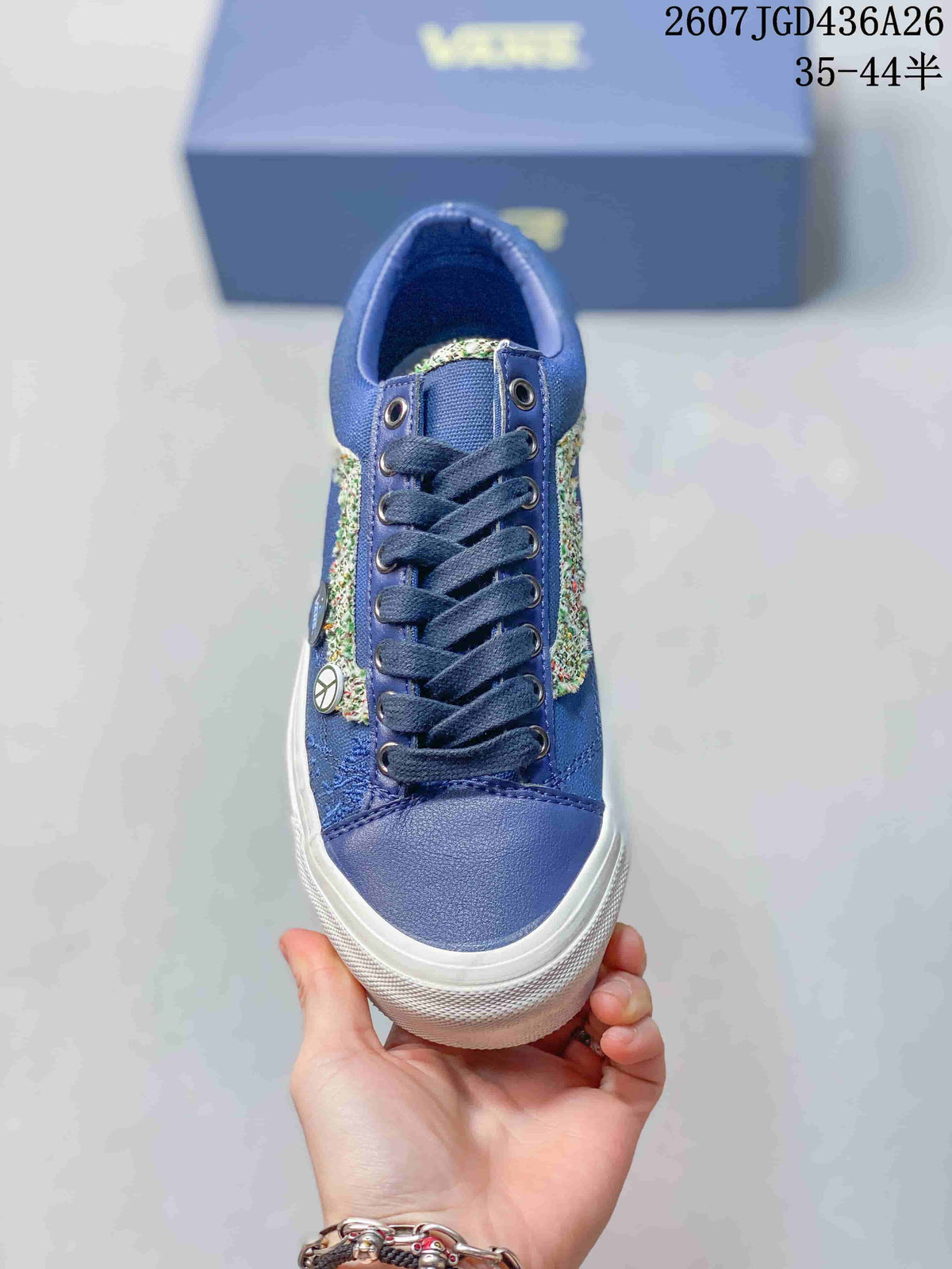 Top view of the blue sneaker showing dark laces, metal eyelets, textured side details, and a white toe bumper.