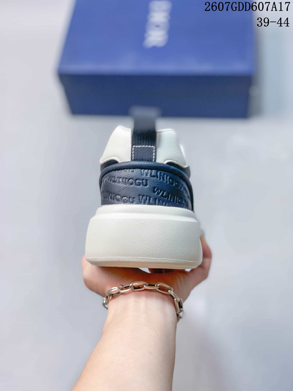 Rear view showing the padded white collar, navy heel panel, and raised white sole.