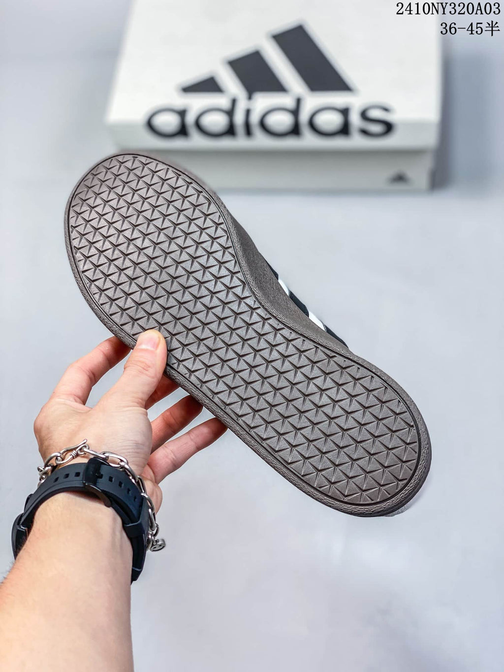 Close view of the brown outsole showing a repeating geometric tread pattern, with an Adidas shoe box in the background.