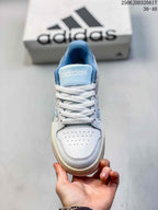 Top view of the sneaker showing white laces, a perforated toe box, blue tongue and adidas branding.