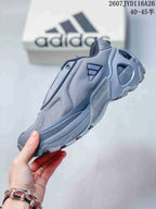 Side view of the gray adidas sneaker showing layered panels, side branding, sculpted midsole, and heel cutout.