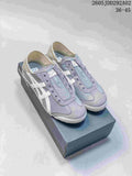 Pair of gray Onitsuka Tiger slip-on sneakers with white side stripes, shown on a branded shoebox.