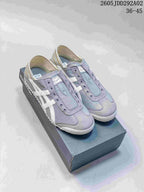 Pair of gray Onitsuka Tiger slip-on sneakers with white side stripes, shown on a branded shoebox.