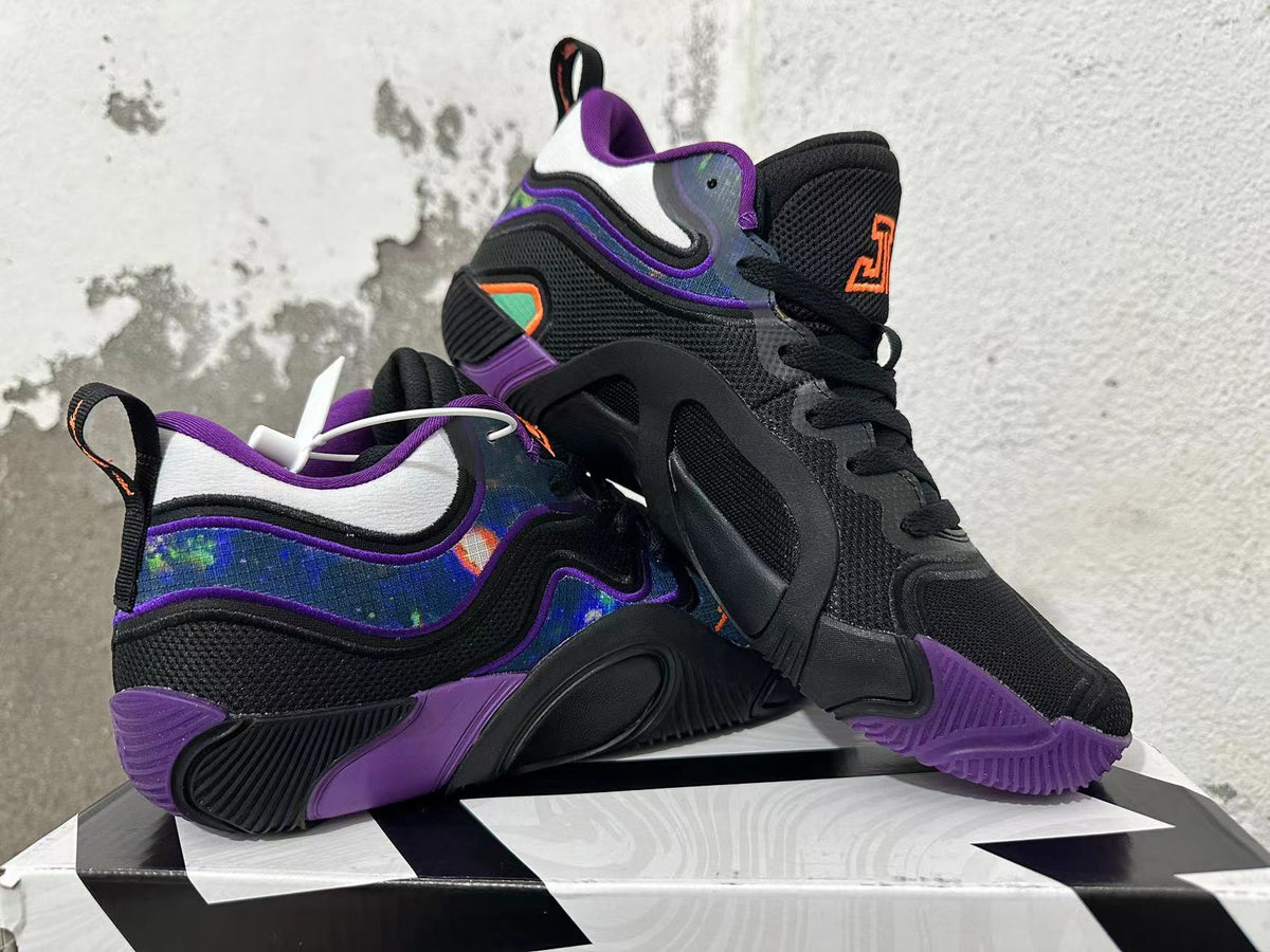 Pair of black and purple Jordan basketball shoes shown at an angle, highlighting the patterned sides and sculpted soles.