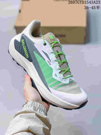 White, gray and green Salomon Genesis shoe with bright green laces and a contrasting outsole.