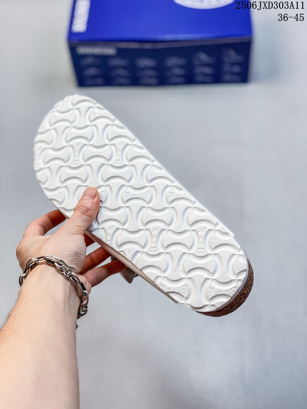 Underside of a white sandal showing patterned tread