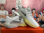 Pair of gray and pale yellow Nike basketball shoes shown from the side and front.
