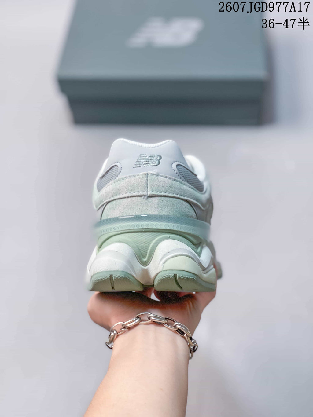 Rear view of the New Balance 9060 sneaker showing the padded heel, layered midsole and mint green heel accent.