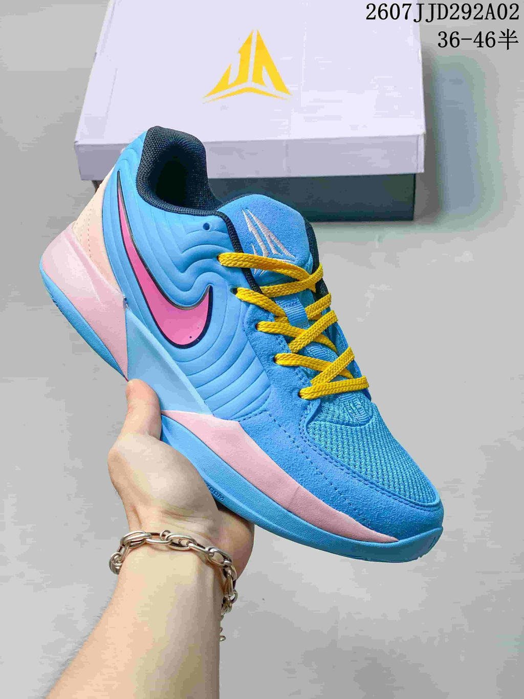 Blue Nike JA 2 basketball shoe with pink detailing and yellow laces.
