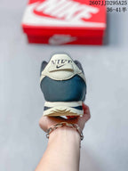 Rear view of the sneaker showing the cream heel tab, Nike branding, navy heel panel, and layered outsole.