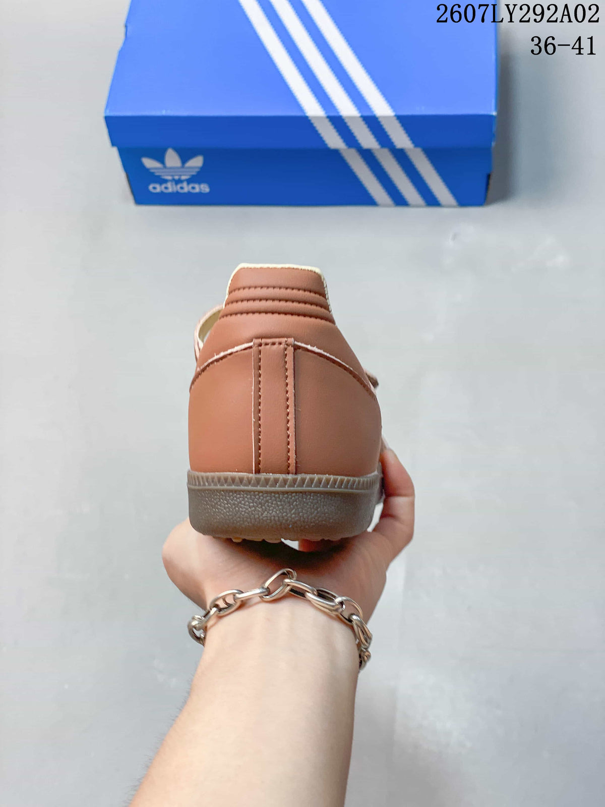 Rear view of the brown sneaker showing the heel construction, cream collar lining, and gum-colored outsole.