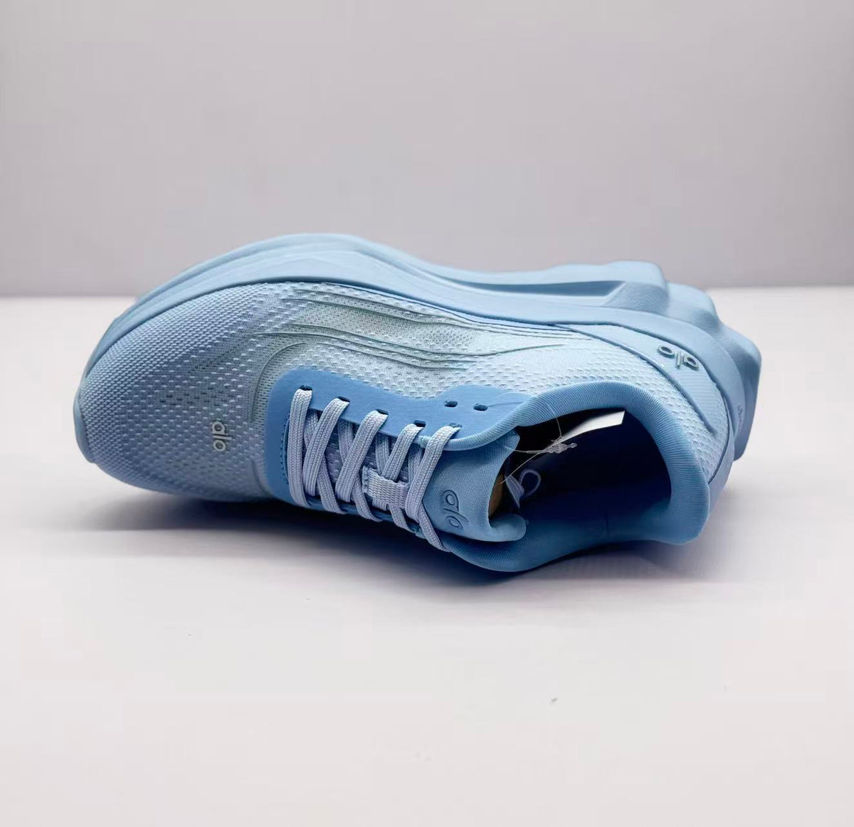 Single light blue sneaker displayed on its side, showing the upper and padded opening.