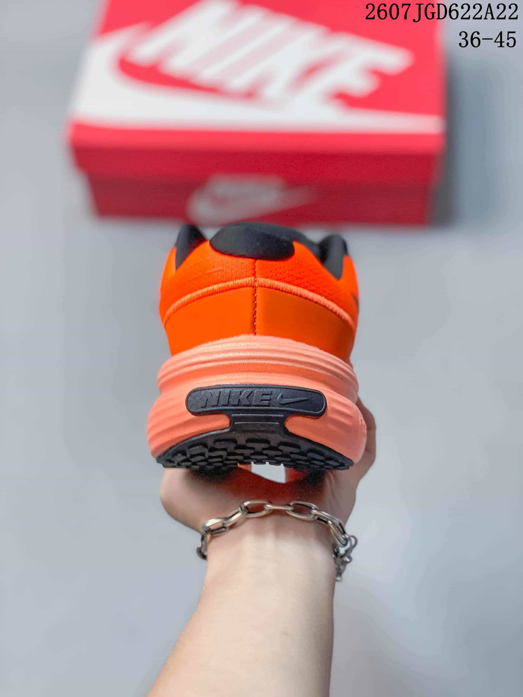 Rear view showing the padded heel, Nike branding, and layered coral-toned sole.