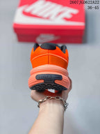 Rear view showing the padded heel, Nike branding, and layered coral-toned sole.