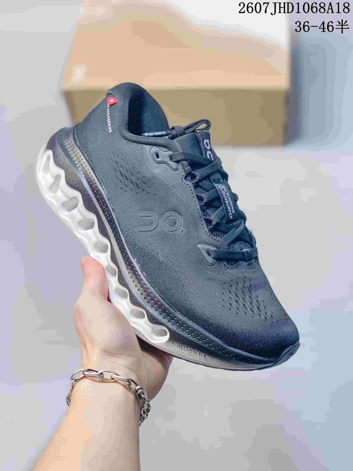 Close side view showing the dark gray upper, On logo, heel construction, and contrasting sculpted outsole.