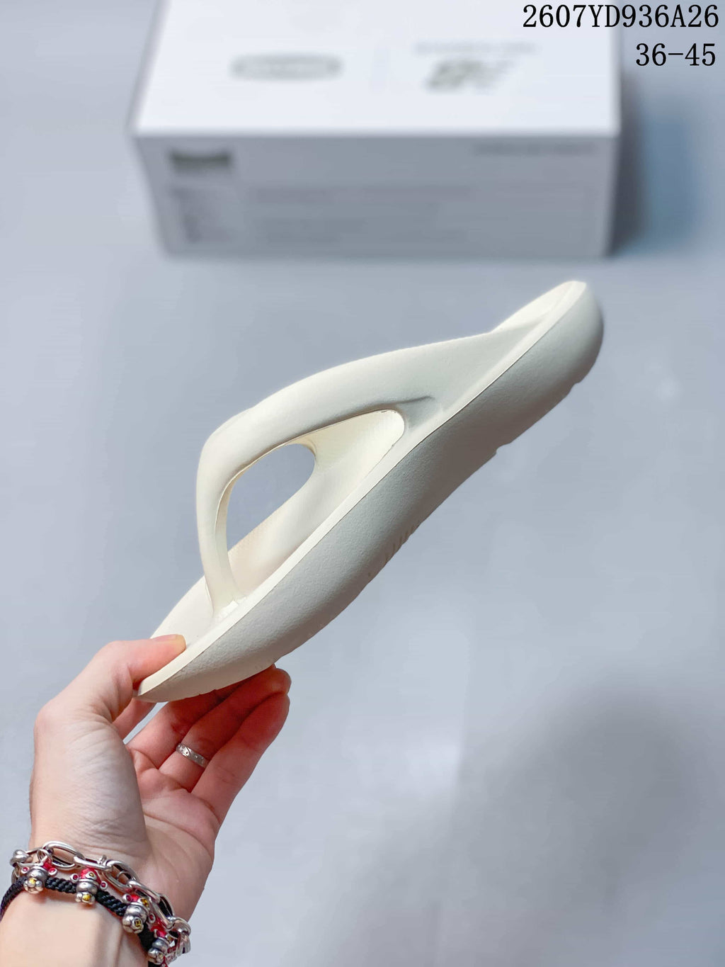 Side profile of the off-white flip-flop sandal showing its sole thickness and open toe-post construction.