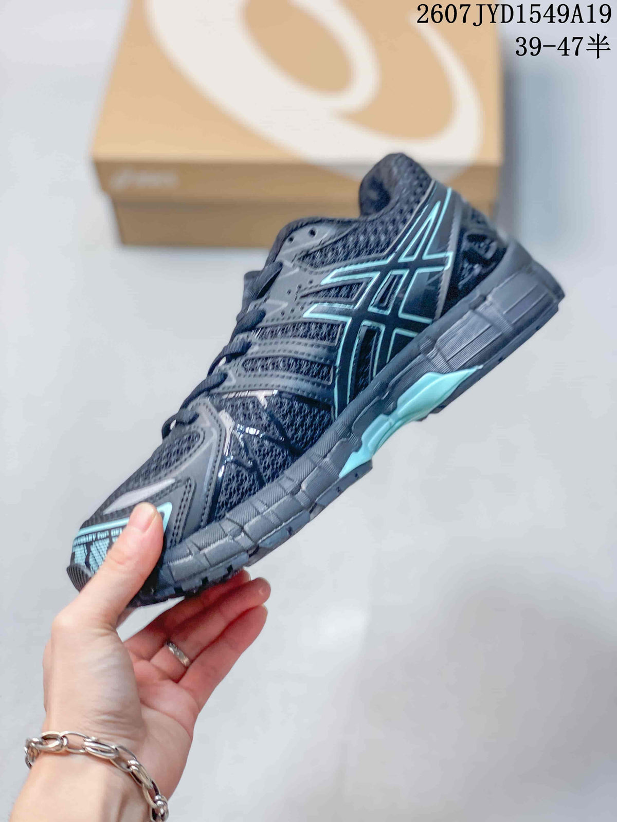 Side profile of a black and gray ASICS Gel-Kayano 20 sneaker with layered overlays, light aqua accents, and a low-top silhouette; image text shows style code 2607JYD1549A19 and size range 39–47.5.