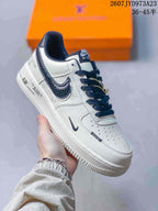 Angled side view showing the white upper, dark textured Swoosh, navy laces, printed midsole details, and rubber outsole.