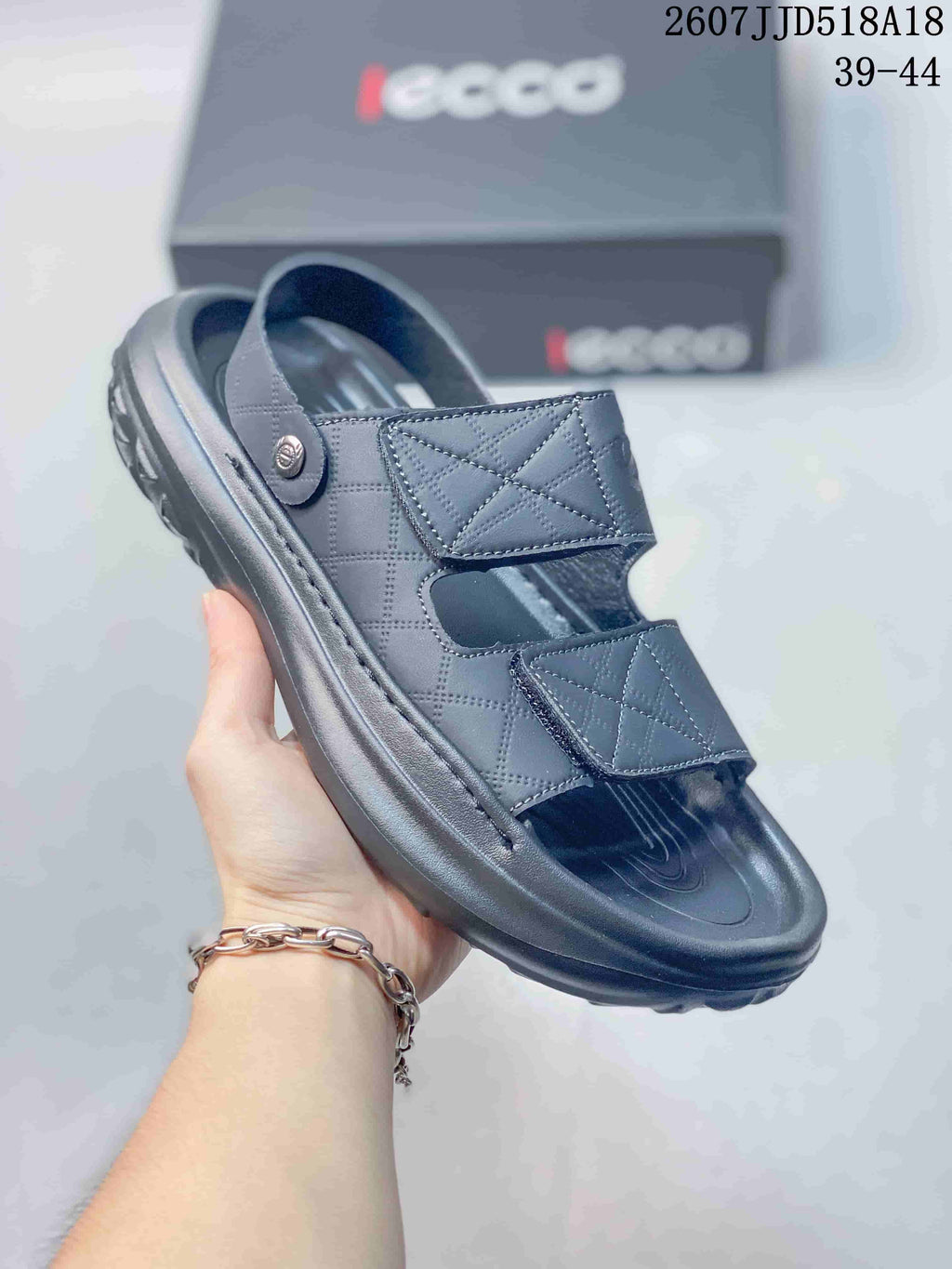 Close-up side view of a black ECCO sandal showing two adjustable straps, a contoured footbed, and textured outsole.