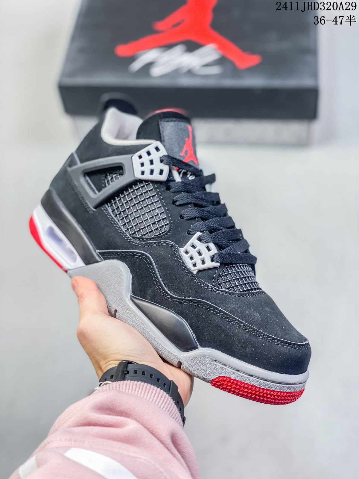 Close-up of a black high-top sneaker with white eyelets, grey midsole details, and a red outsole section.