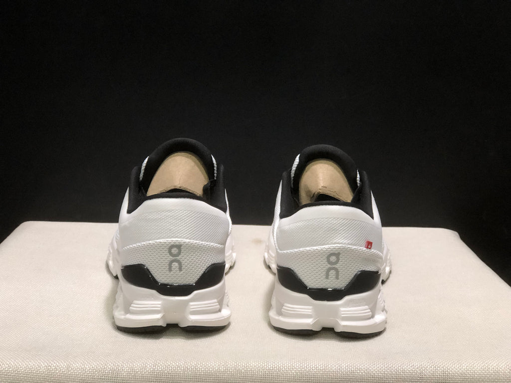Rear view showing the black heel accents, On branding, and segmented outsole of the sneakers.