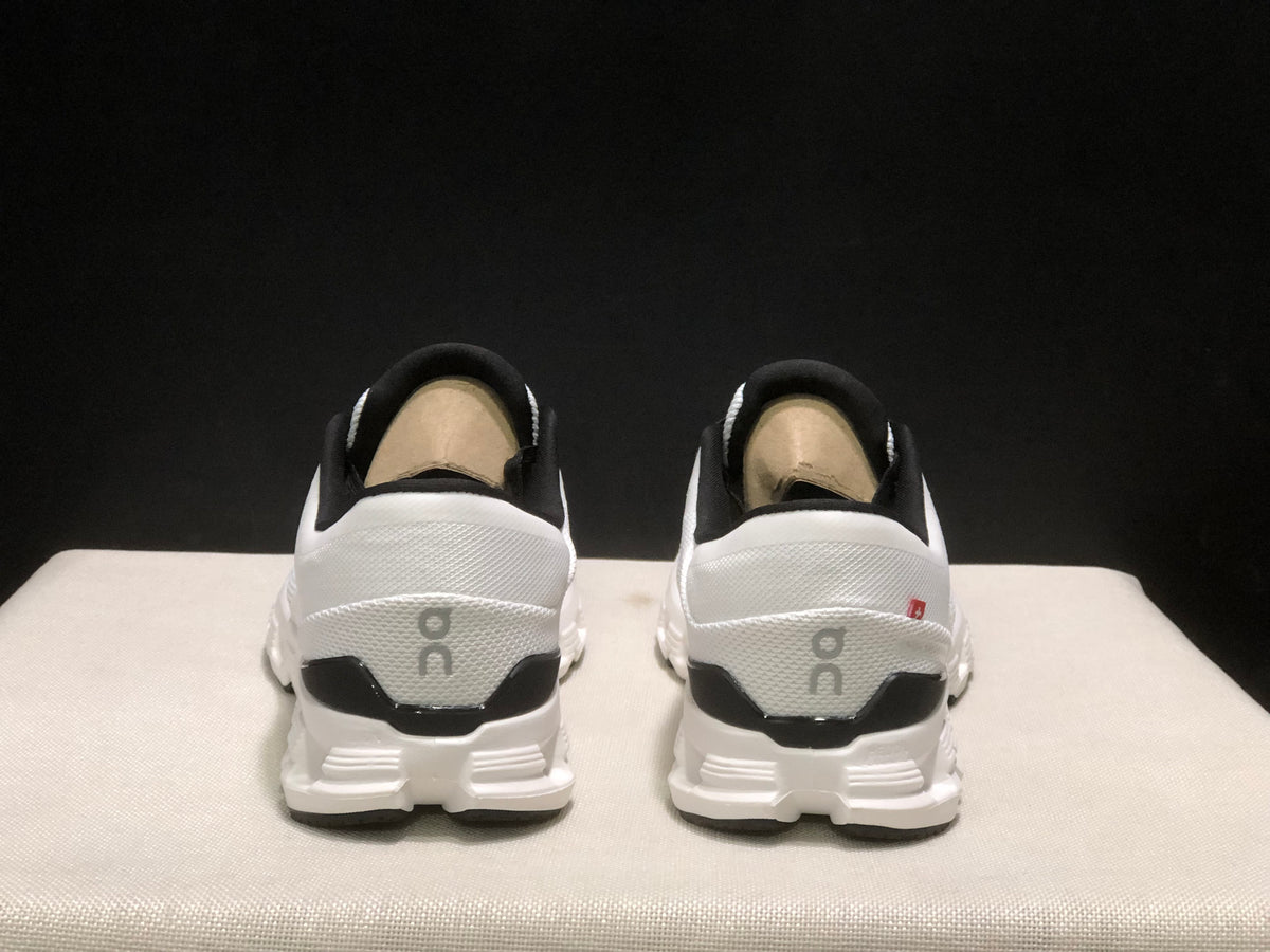 Rear view showing the black heel accents, On branding, and segmented outsole of the sneakers.