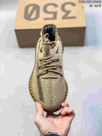 Top view of a beige knit sneaker showing the rounded toe, tonal laces, and textured upper pattern.