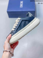 Side view of the navy sneaker showing the woven-texture panel, cream laces and thick cream outsole.