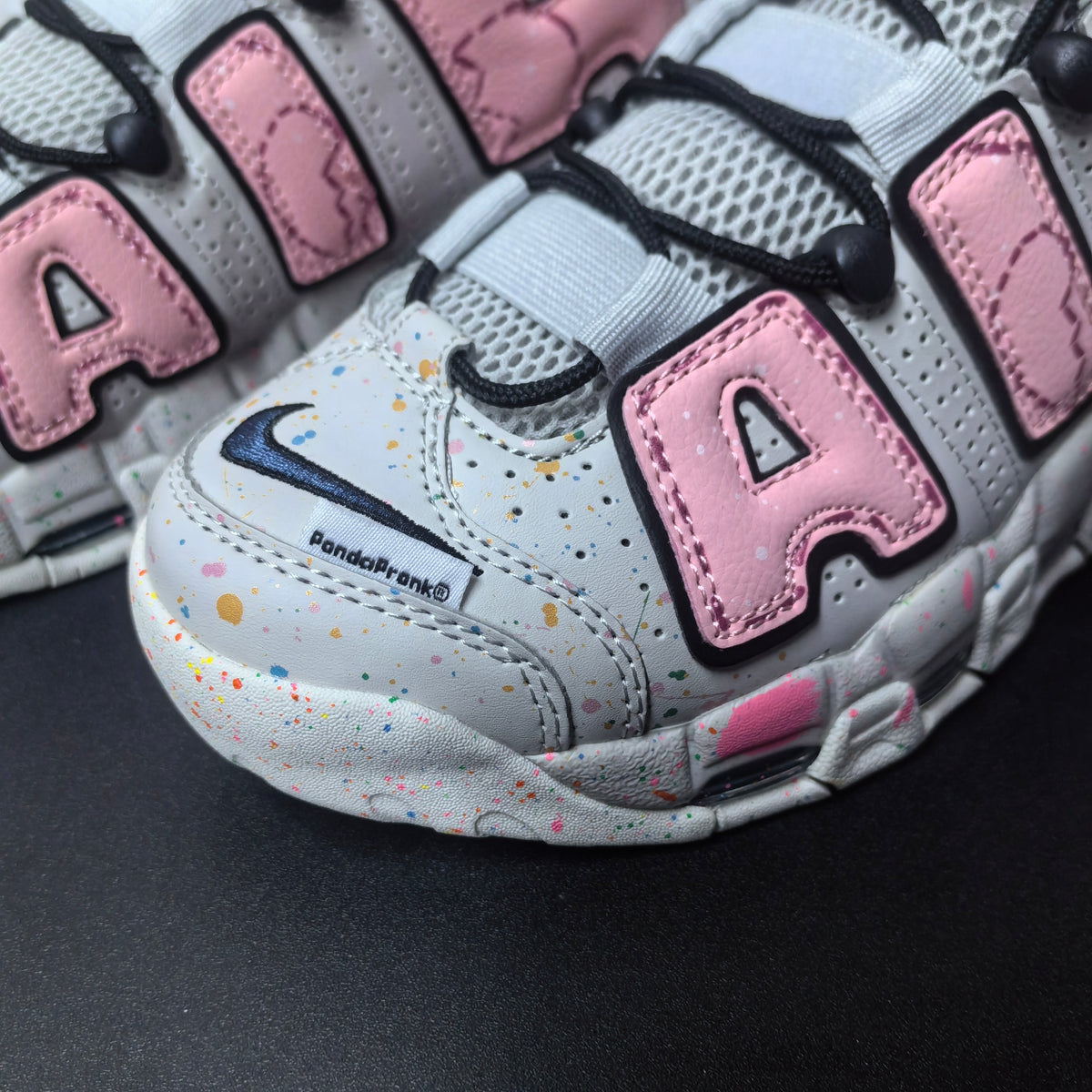 Close-up of pink AIR lettering, perforated panels, and multicolor speckle details