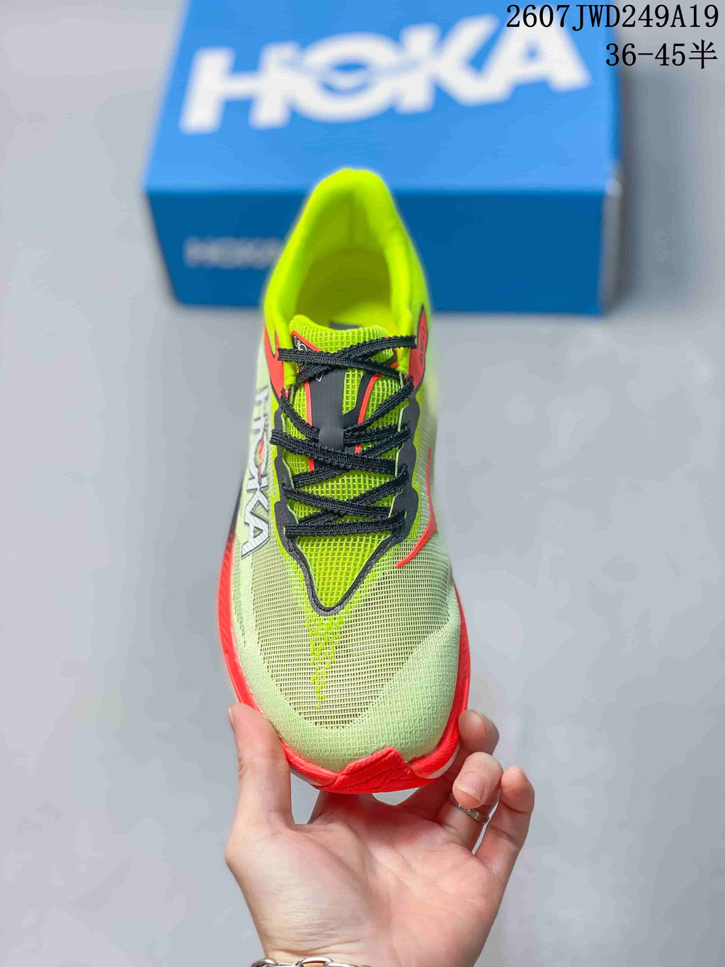 Top view of the green running shoe with black laces, coral detailing, and a structured tongue.