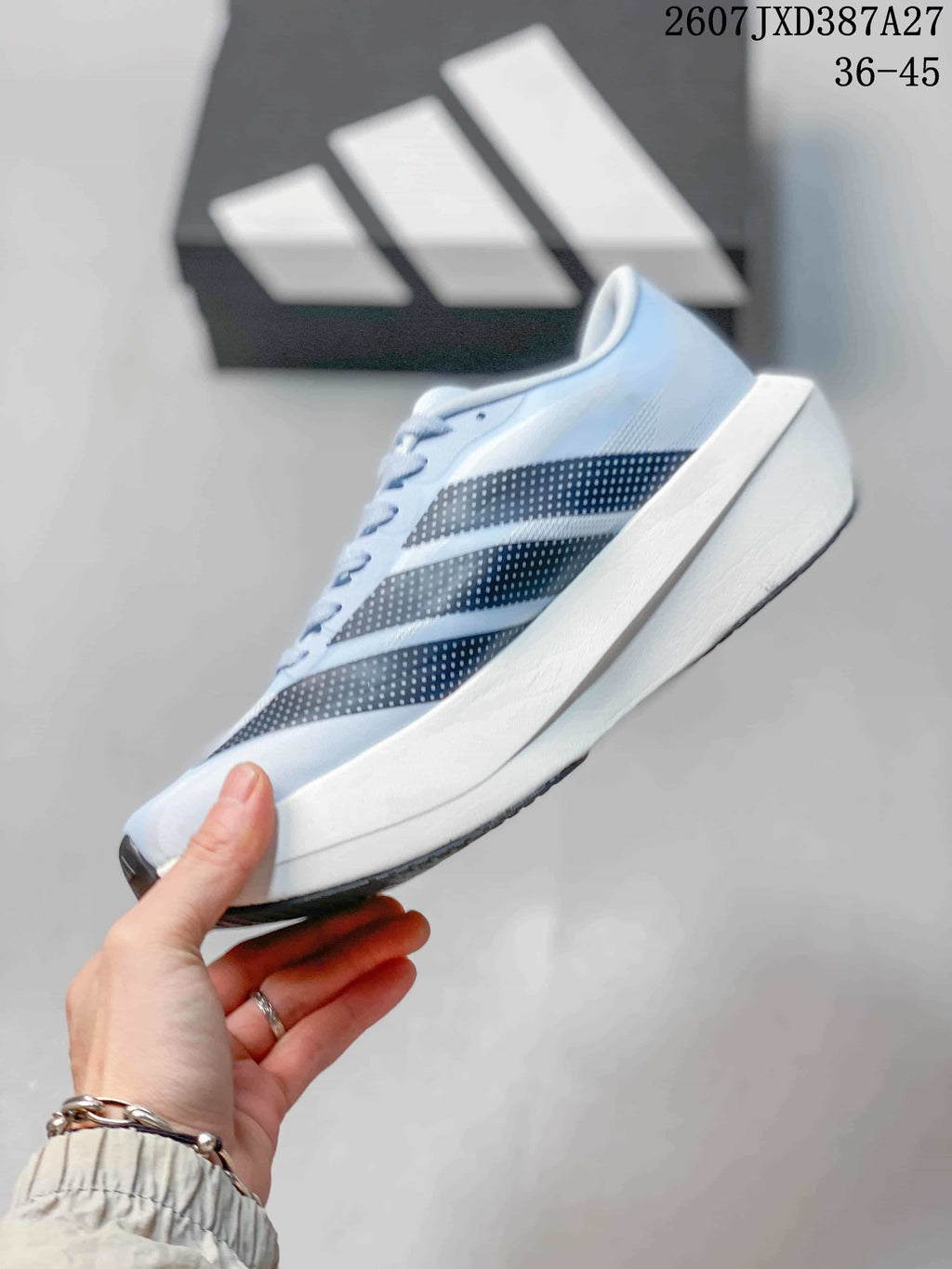 Side profile of the light blue running shoe showing the dotted adidas stripes and raised white midsole.