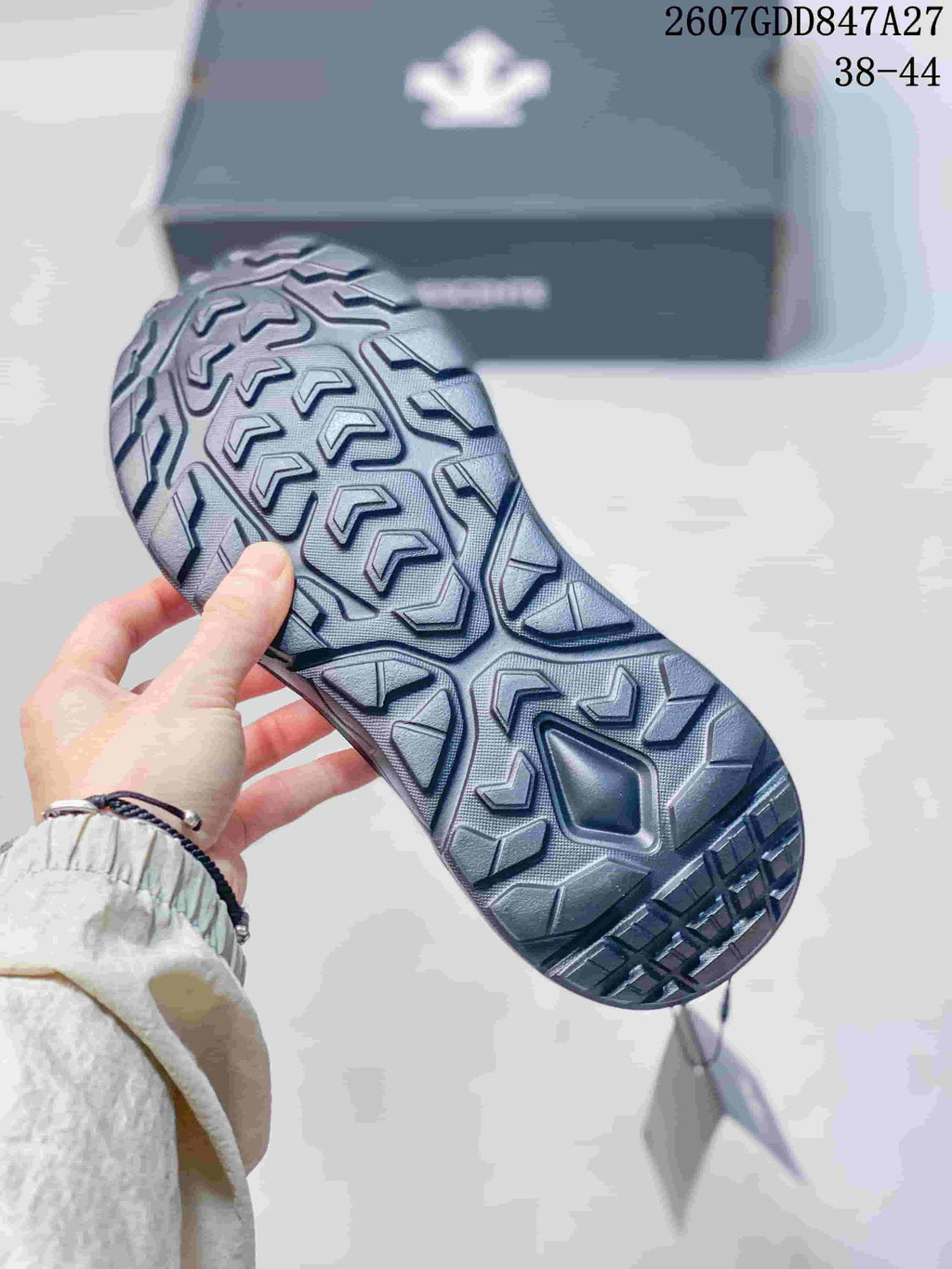 Close view of the sneaker outsole showing a deep, geometric tread pattern; overlay text shows 2607GDD847A27 and size range 38–44.