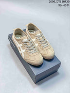 Beige Onitsuka Tiger low-top sneakers with white side stripes on a shoebox