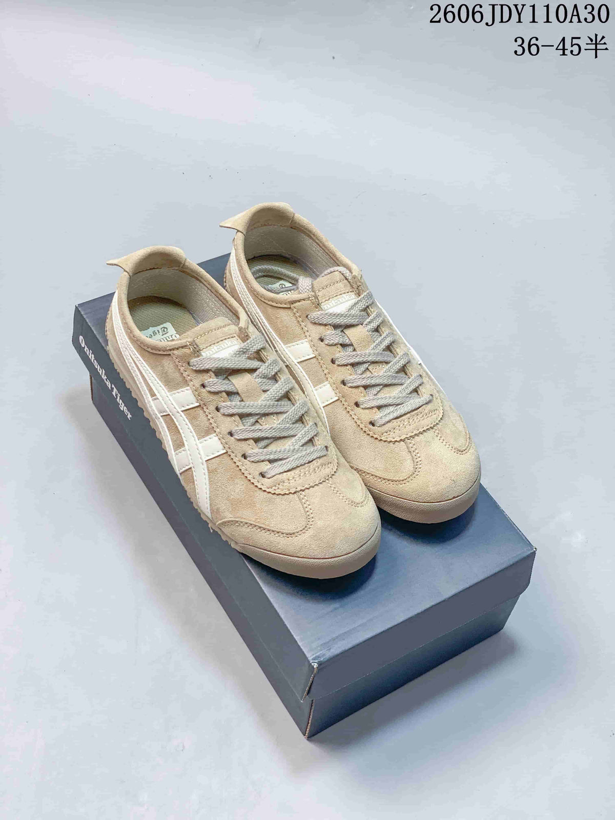 Beige Onitsuka Tiger low-top sneakers with white side stripes on a shoebox