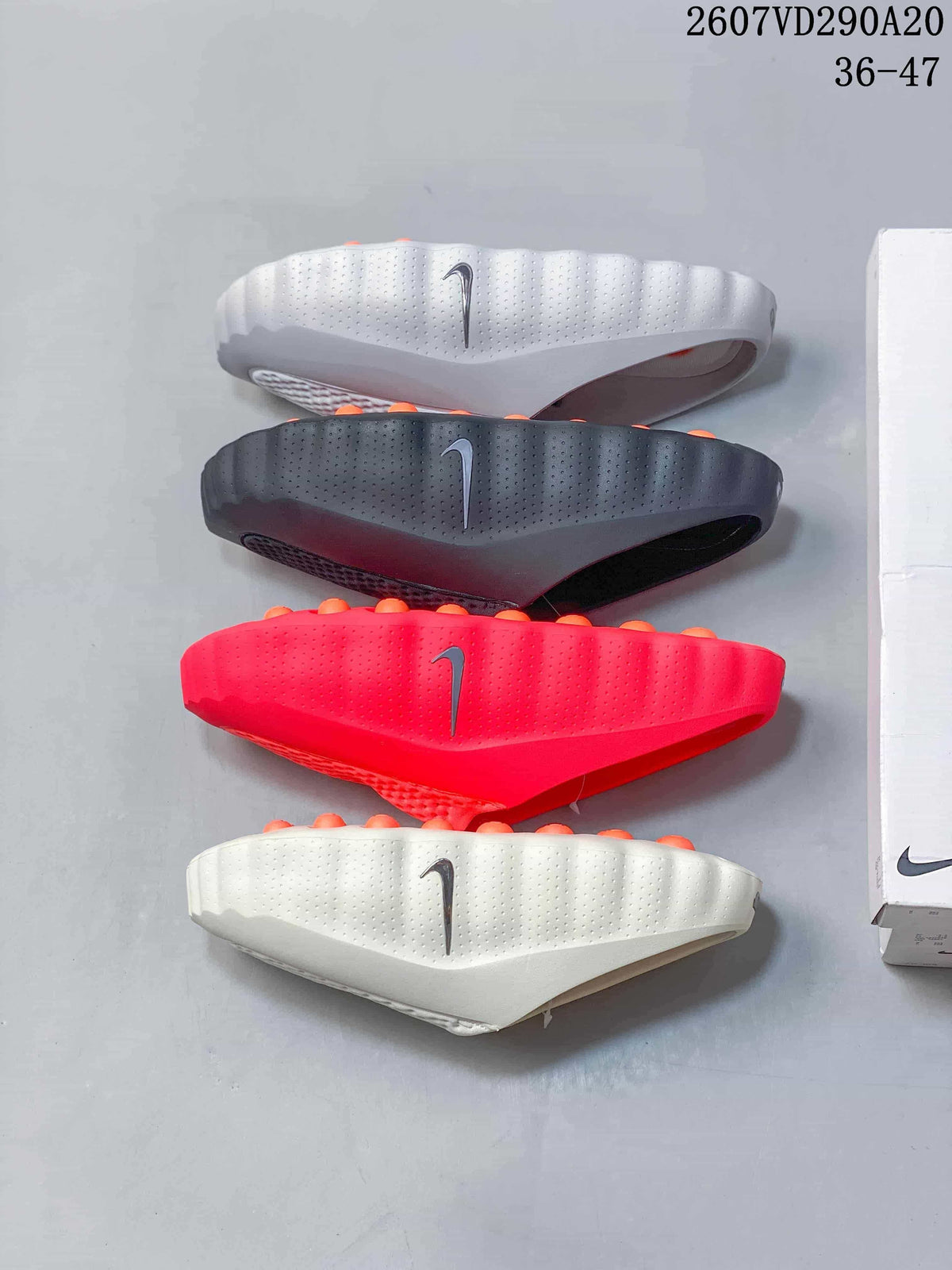 Side profile comparison of white, dark gray and bright red slides showing the sculpted soles and raised orange footbed details.