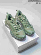 Pair of green Alo Runner Trail sneakers displayed on a shoebox, showing the low-top shape, quick-lacing system, and lugged outsole.