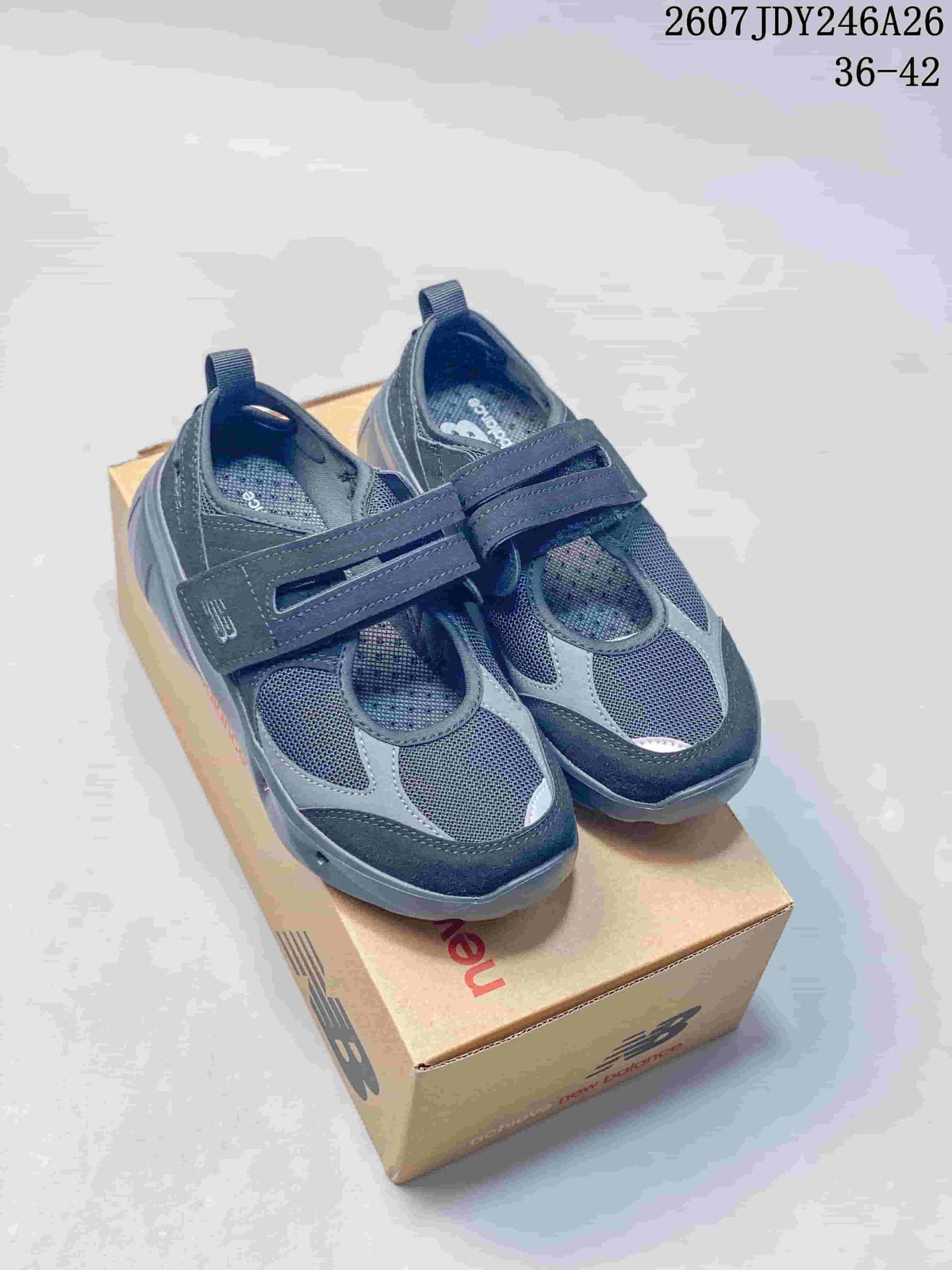 Pair of dark navy and gray New Balance Breeze sneakers displayed on a branded shoebox.