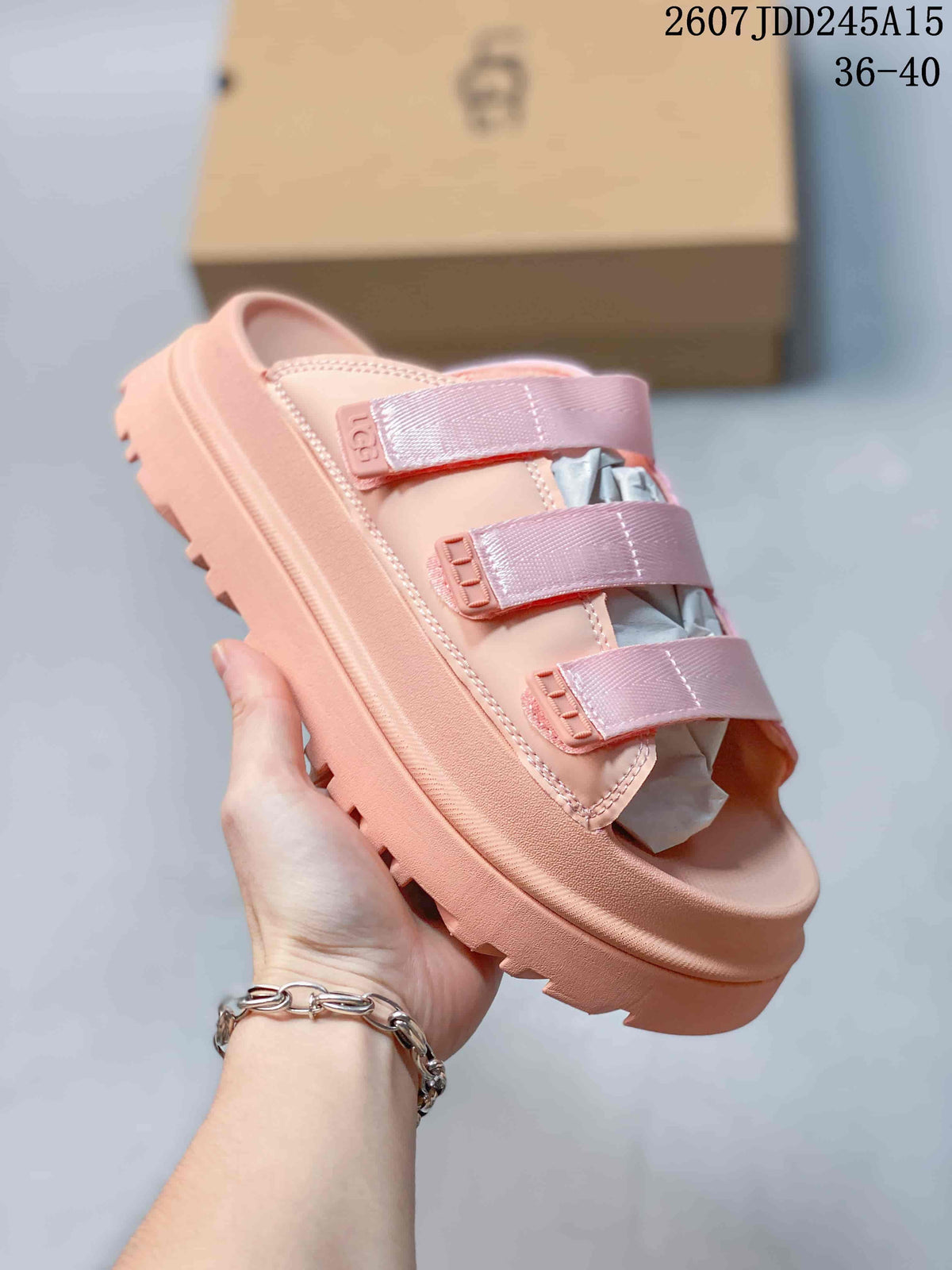 Close-up side view of a pink UGG GoldenGlow slide sandal with three adjustable straps.