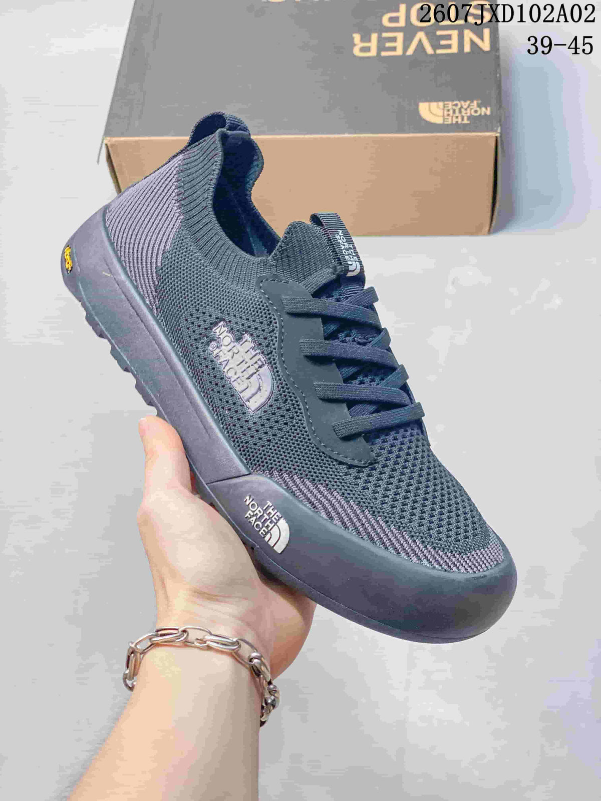 Side view of a dark blue-gray The North Face Dune sneaker with knit-look upper and contrasting sole.