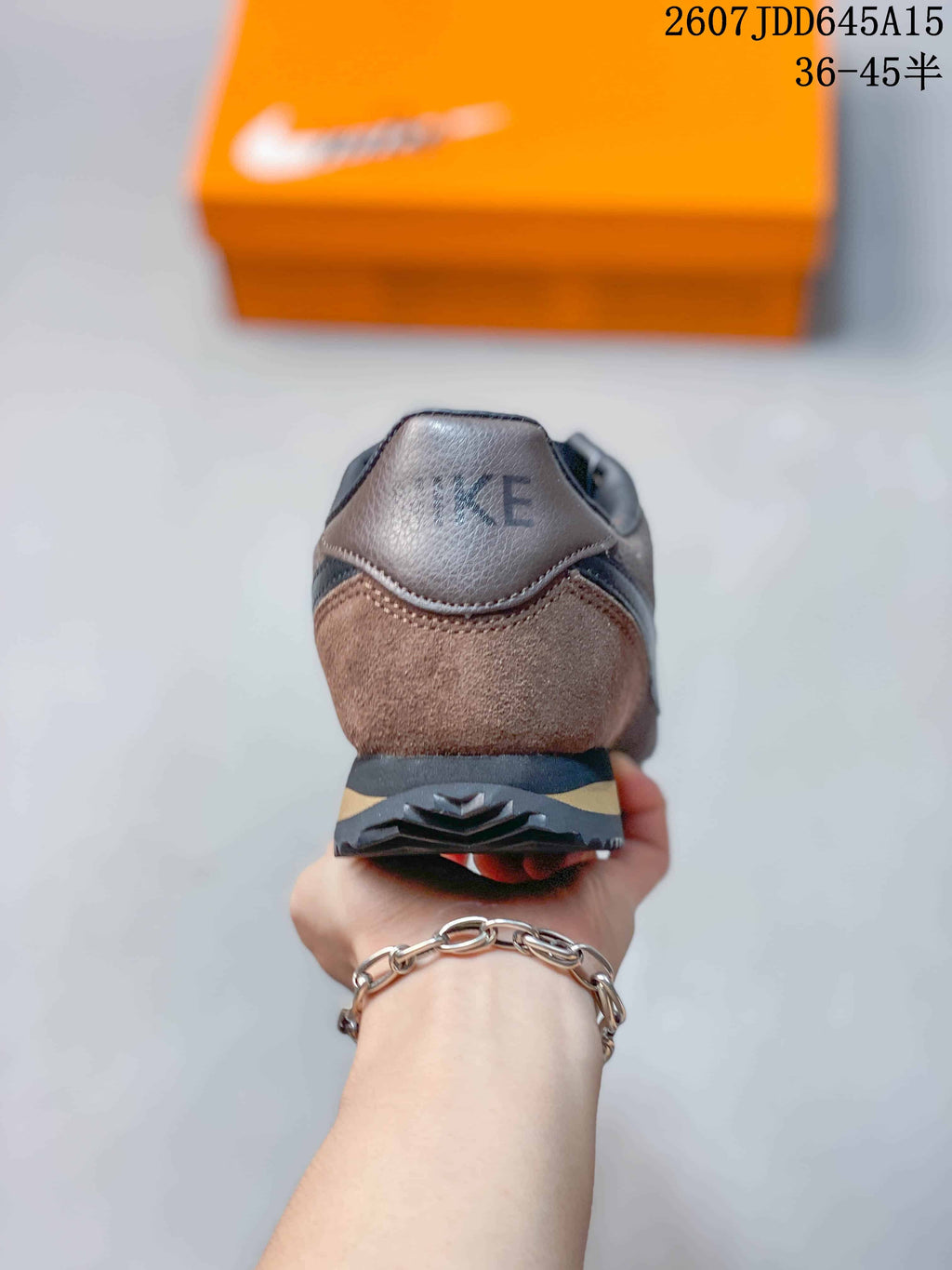 Rear view of the brown and black sneaker showing the padded heel collar and layered outsole.