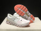 Angled view of the shoes with one outsole visible, showing coral traction sections and segmented construction.