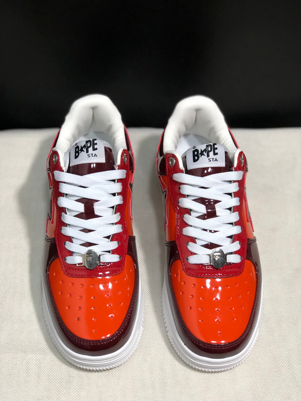 Front view highlighting the orange toe boxes, white laces, metal lace details and padded collars.
