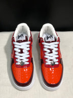 Front view highlighting the orange toe boxes, white laces, metal lace details and padded collars.
