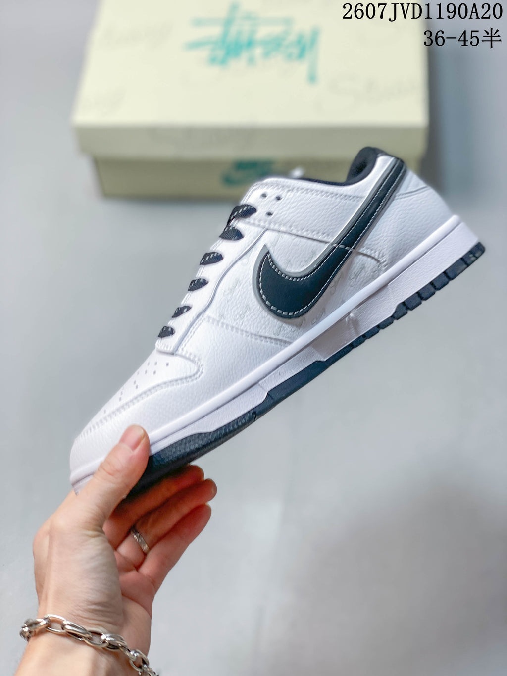 Side profile of the white low-top sneaker with a black Swoosh, contrast stitching, and dark outsole.