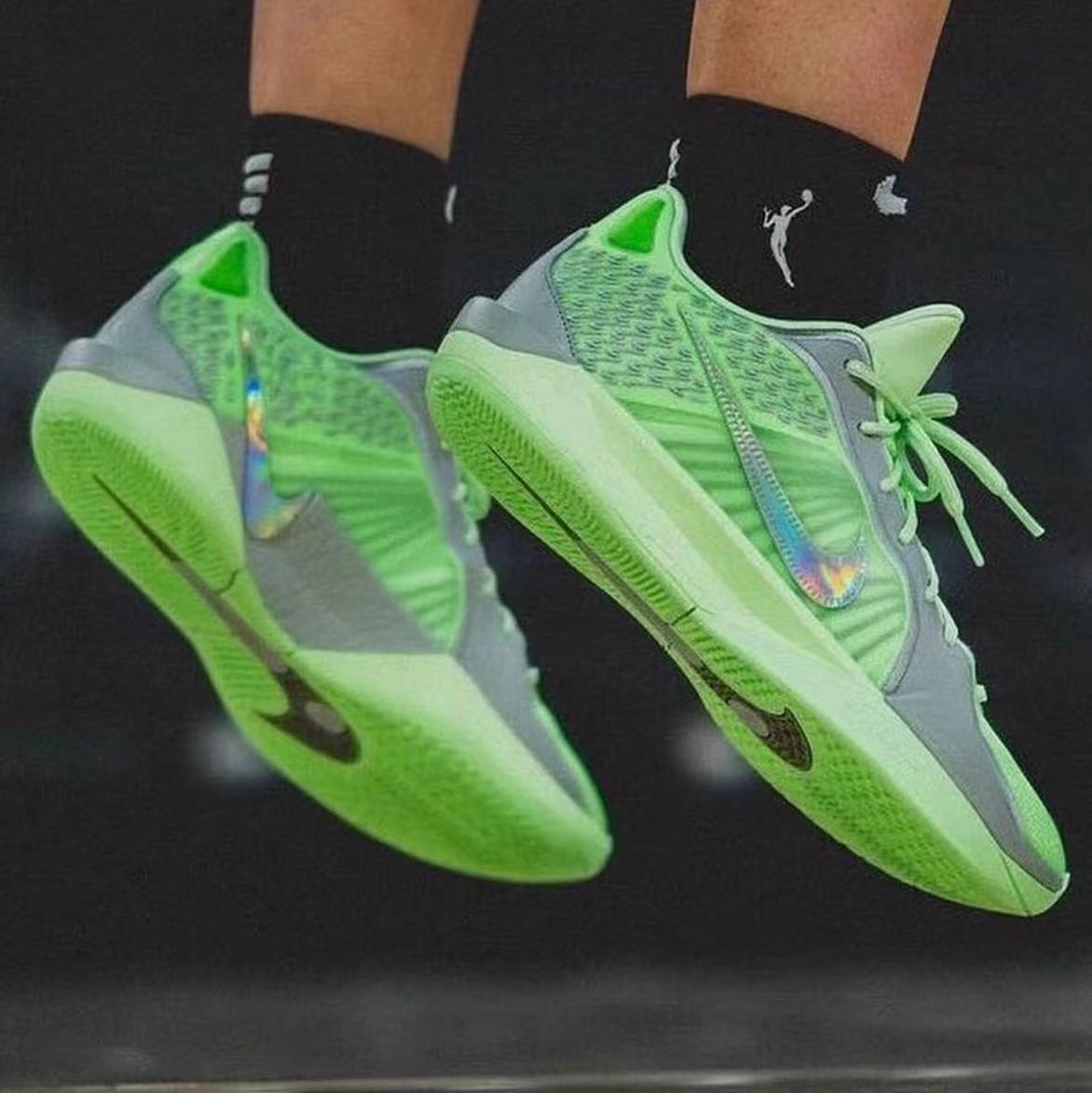 Pair of green and gray Nike basketball shoes with lace-up closures and iridescent side accents