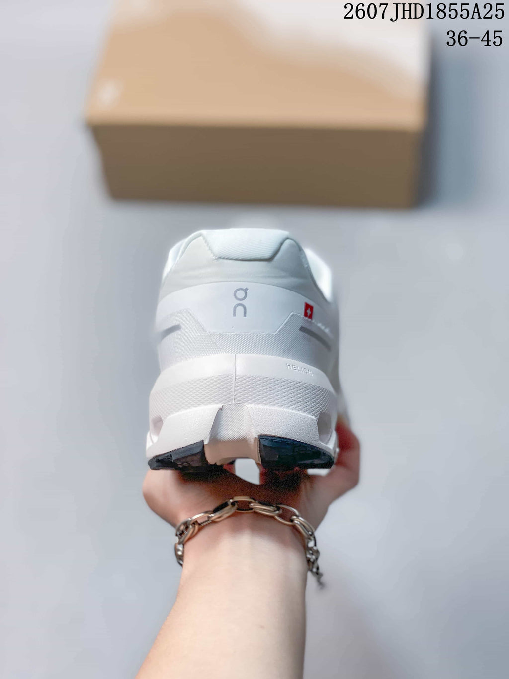 Rear view of the white sneaker showing the padded heel, On branding, and dark outsole sections; overlay text shows style code 2607 JHD1855A25 and size range 36-45.