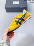 Side view highlighting the yellow upper, black side stripes, white midsole, and textured outsole.