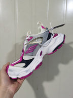 Close-up view of grey, white, black and pink Balenciaga sneakers showing layered panels, mesh sections and a chunky outsole.