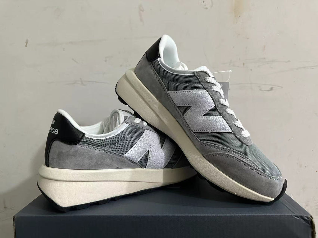 Pair of gray and white New Balance U370 sneakers shown at an angle.