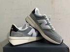 Pair of gray and white New Balance U370 sneakers shown at an angle.